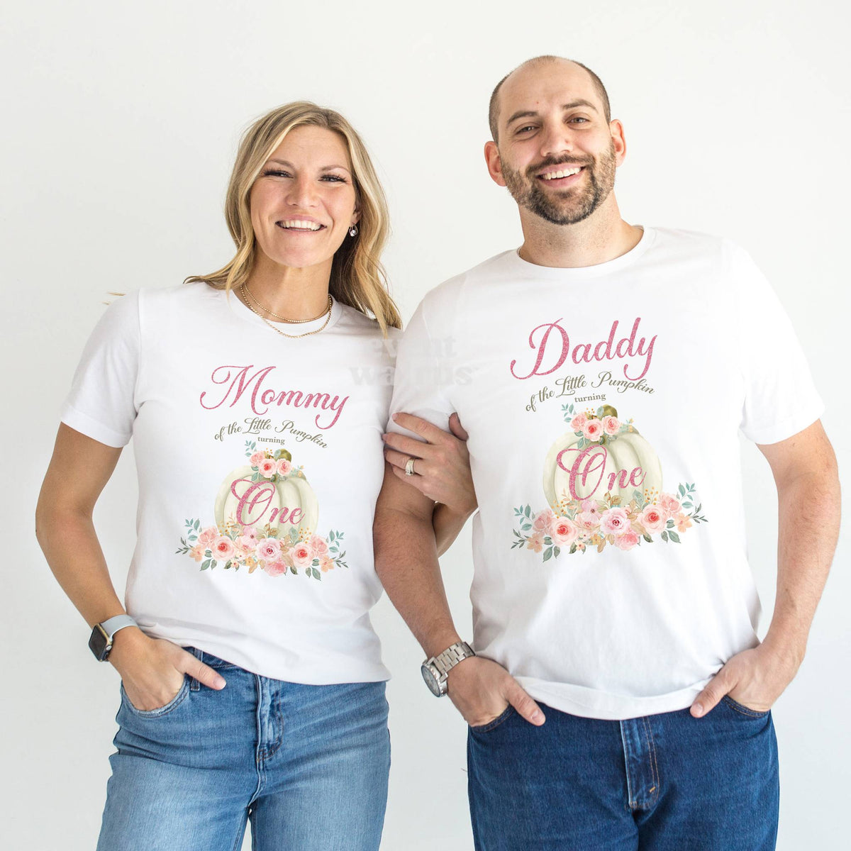 Mom and Dad in white Little Pumpkin shirts with a cream pumpkin, blush roses and pink glitter