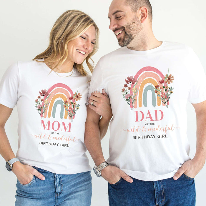 Mom and Dad laughing together in white rainbow Wild and Onederful Birthday Girl shirts.