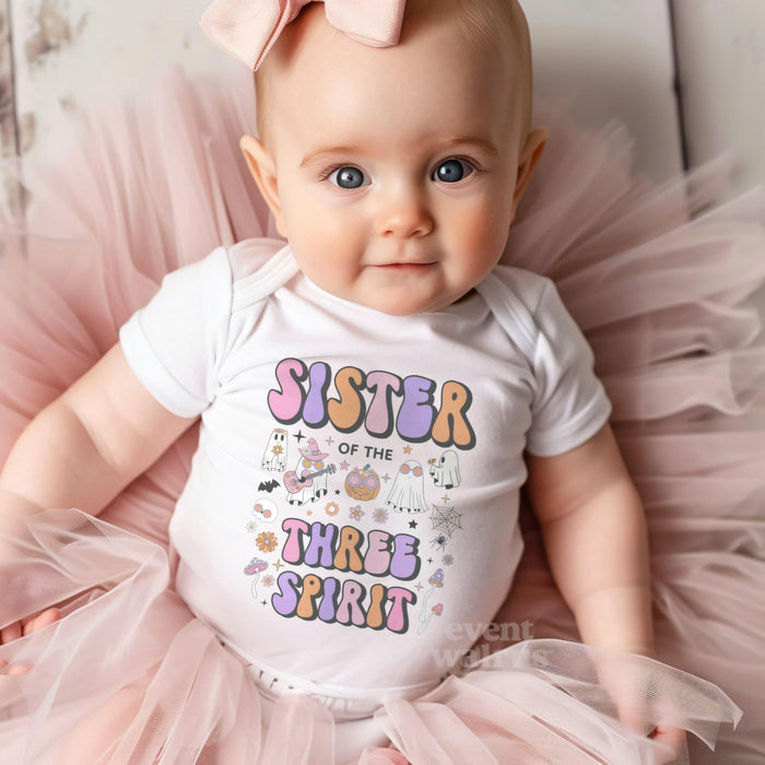 Baby girl with a pink bow on tulle in a white Sister of the Three Spirit bodysuit.