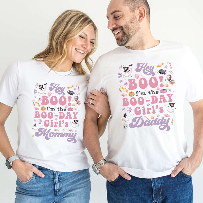 Mom and Dad laughing together in white Hey Boo Boo-Day Girl's Mommy and Daddy shirts.