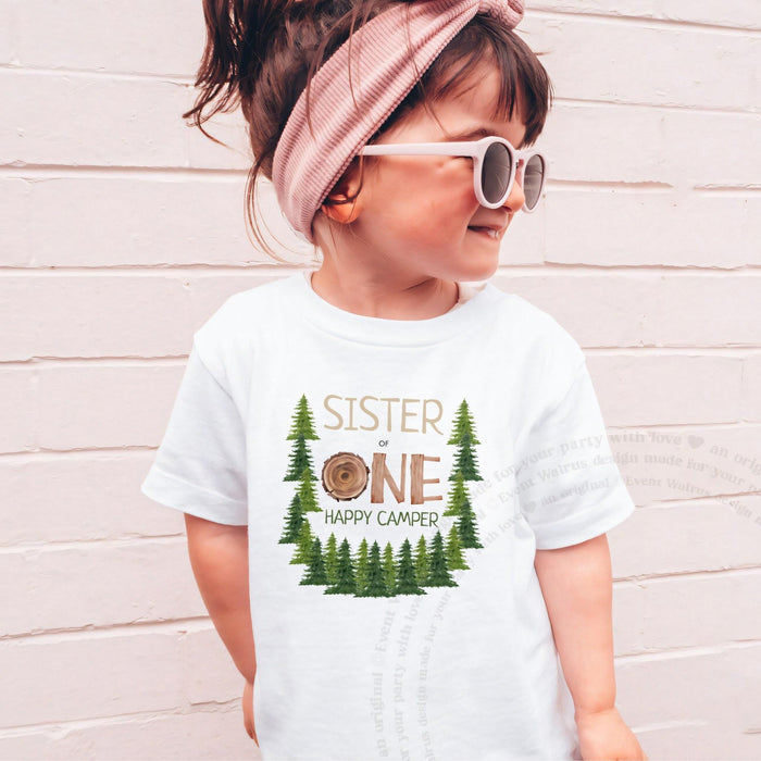 Girl in sunglasses and a pink headband wearing a white Sister One Happy Camper shirt.