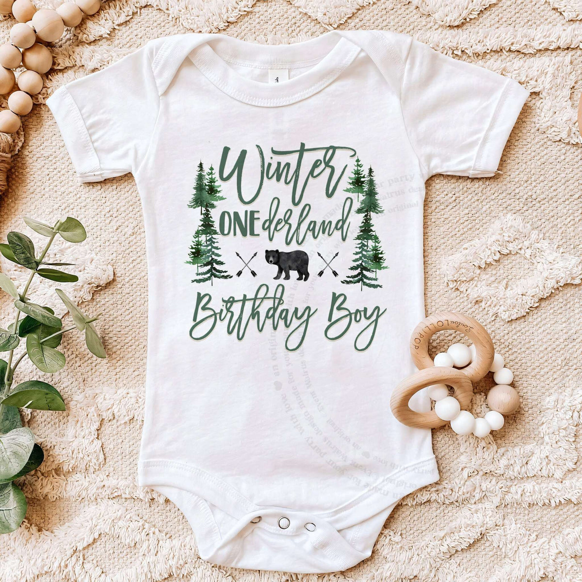 White bear forest Birthday Boy bodysuit on a beige blanket with a wooden teether.