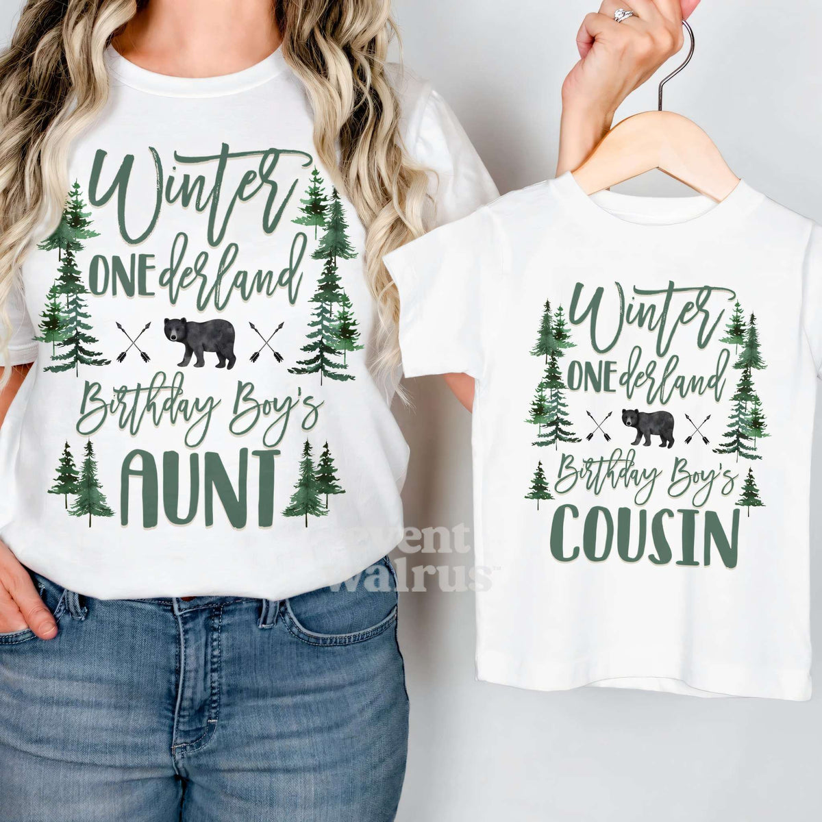 Aunt holding up a white Cousin bear forest tee on a hanger while wearing her own.