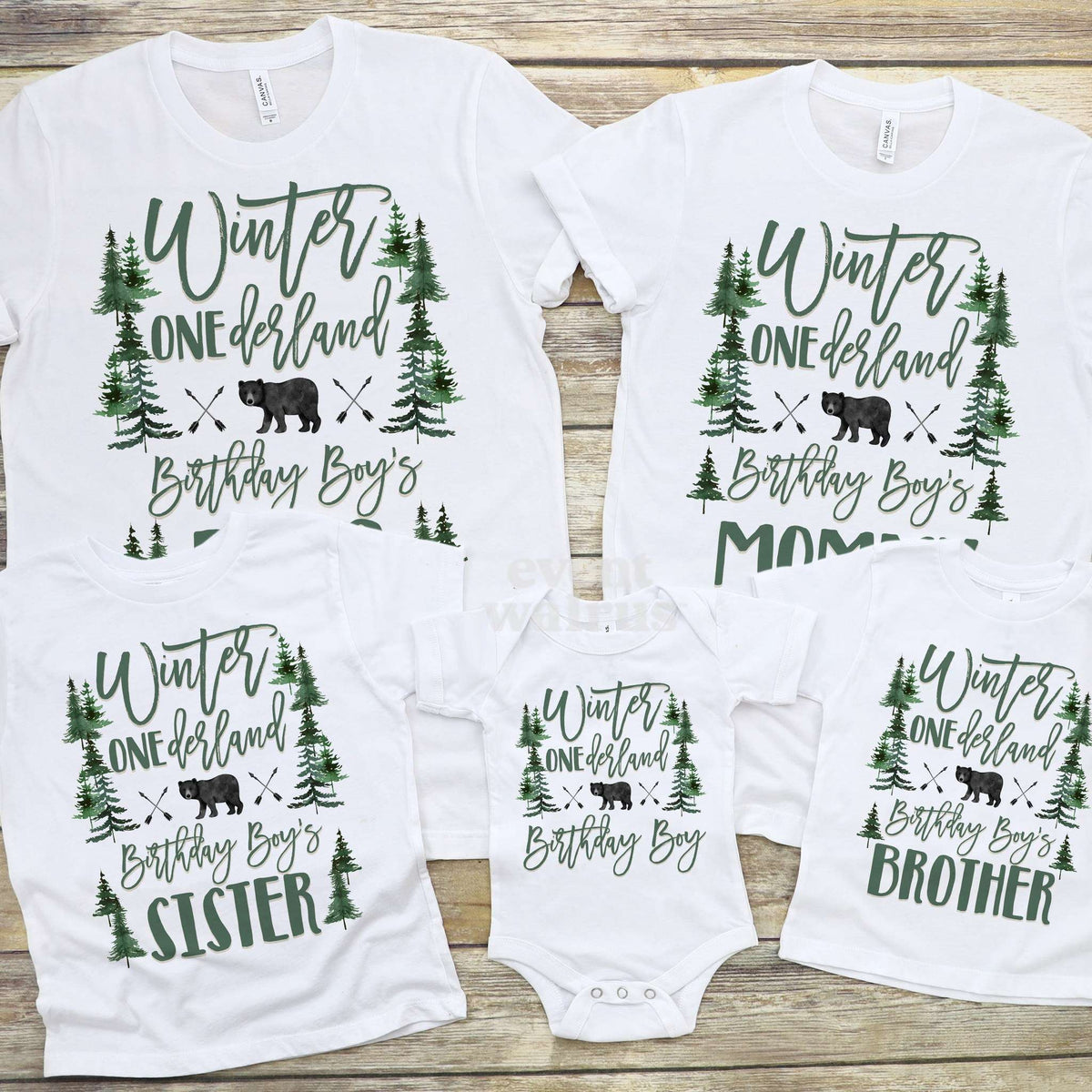 Sister and Brother bear forest tees laid out with the parents' shirts and the baby bodysuit.