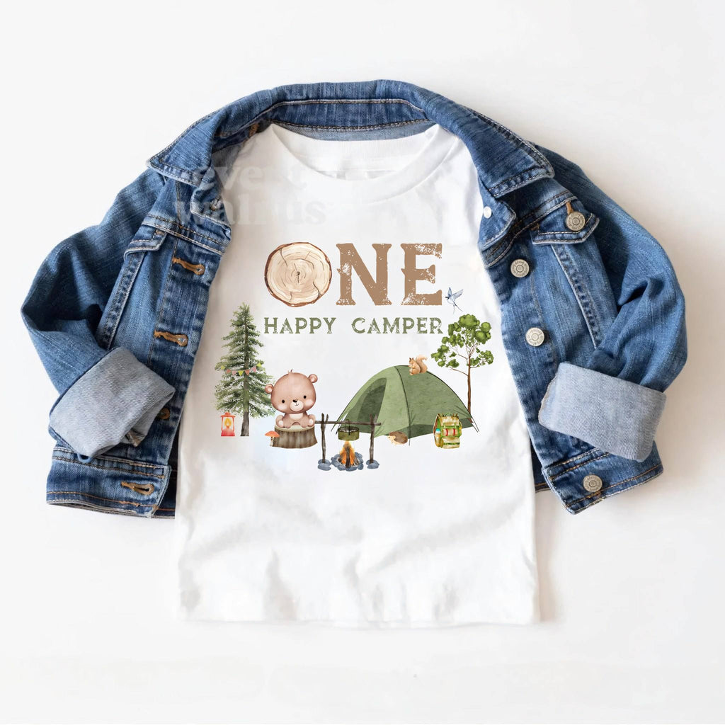 White One Happy Camper toddler tee laid on a denim jacket.