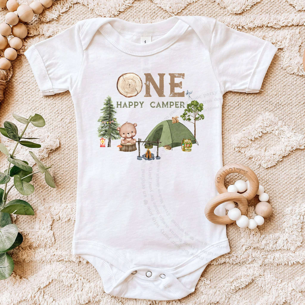 White One Happy Camper bodysuit on a beige blanket with a wooden teether.