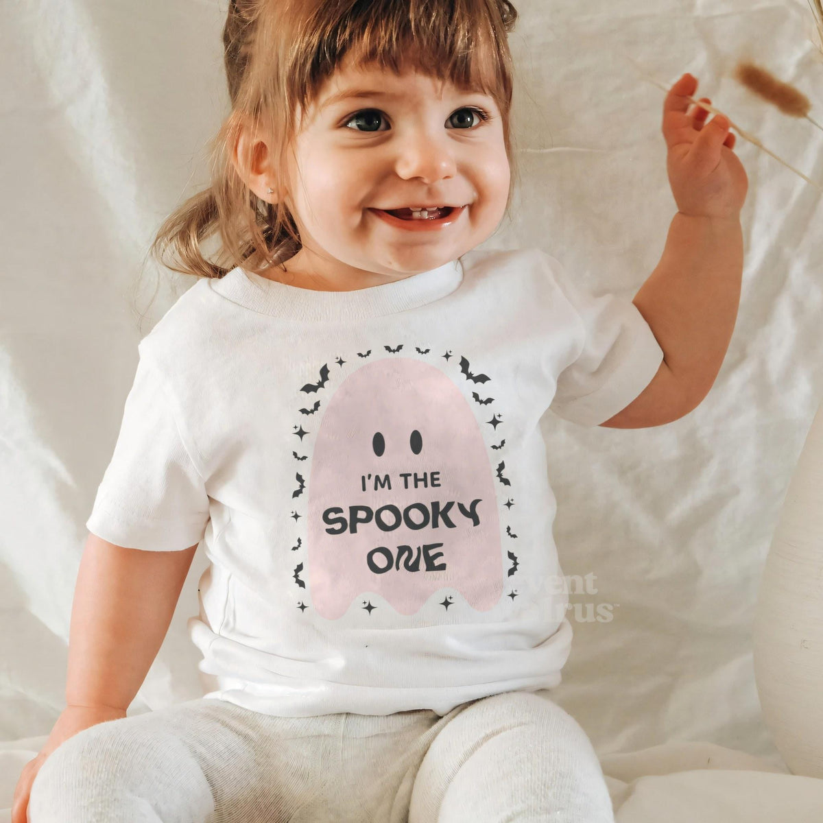 Laughing baby girl in a white I'm the Spooky One baby tee.