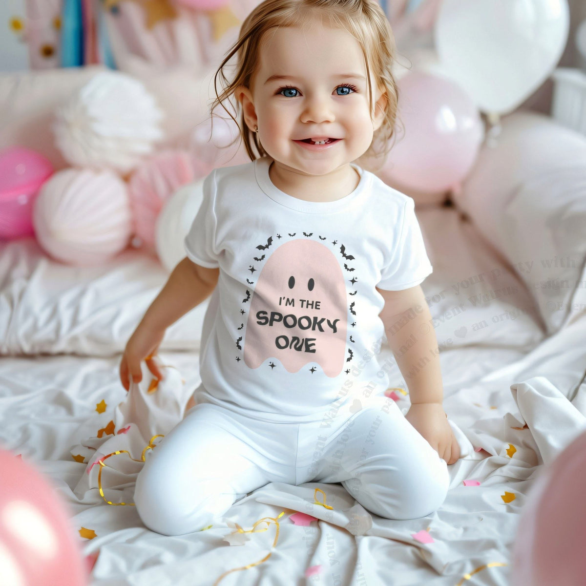 Smiling toddler girl among pink balloons in a white I'm the Spooky One pink ghost tee.