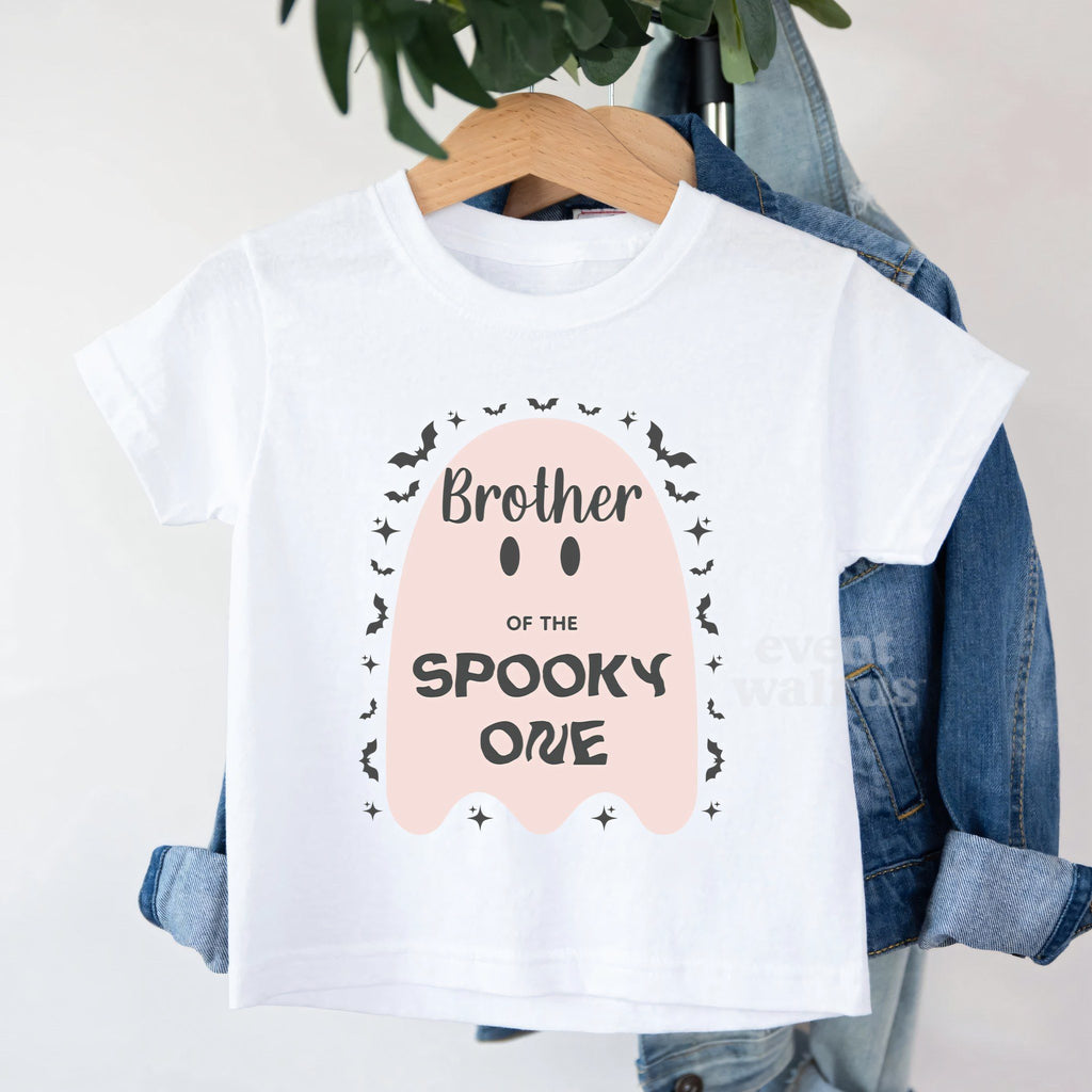 White Brother of the Spooky One toddler tee on a hanger over a denim jacket.