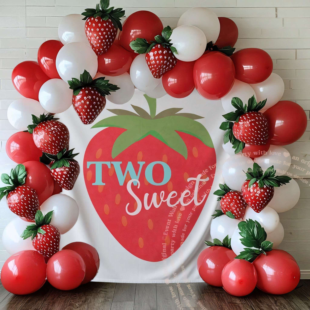 Big strawberry two sweet backdrop framed by red and white balloons and strawberry balloons.