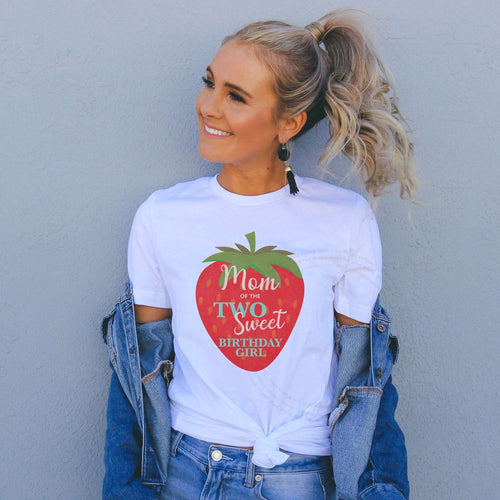 Smiling woman in a denim jacket wearing a white Mom of the Two Sweet Birthday Girl shirt.