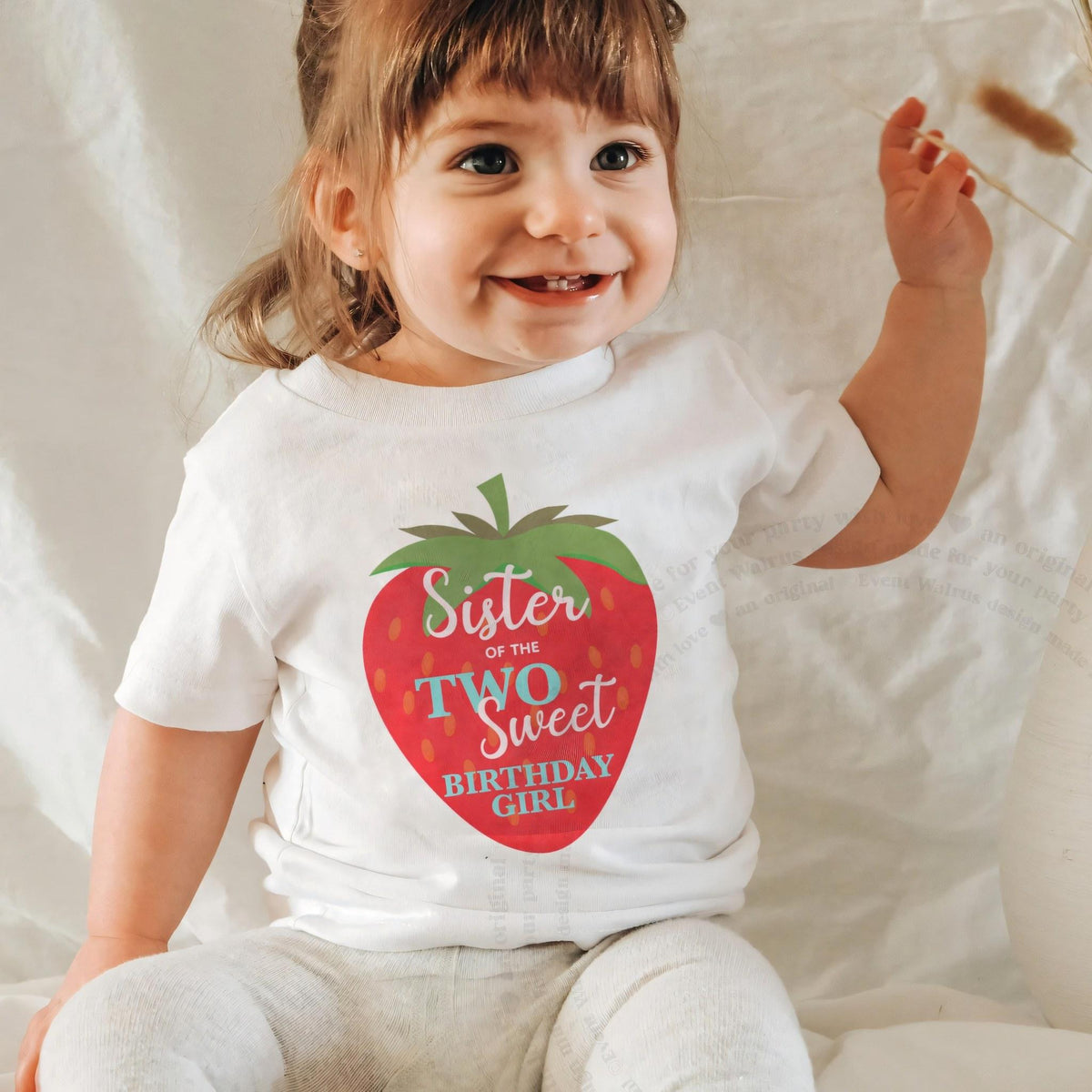 Laughing baby girl in a white Sister of the Two Sweet baby tee.