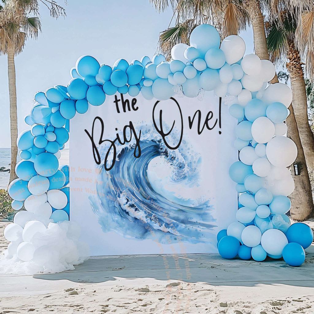 Blue wave backdrop under palm trees with a light blue and white balloon garland.