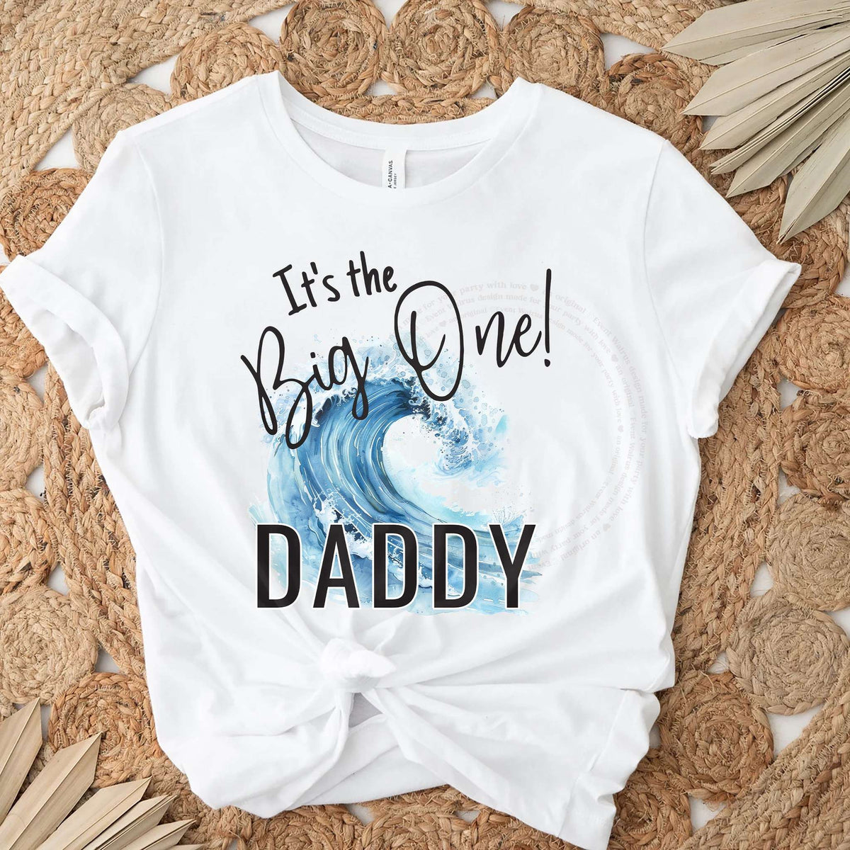 White It's the Big One Daddy tee with a crashing blue wave on a jute rug.