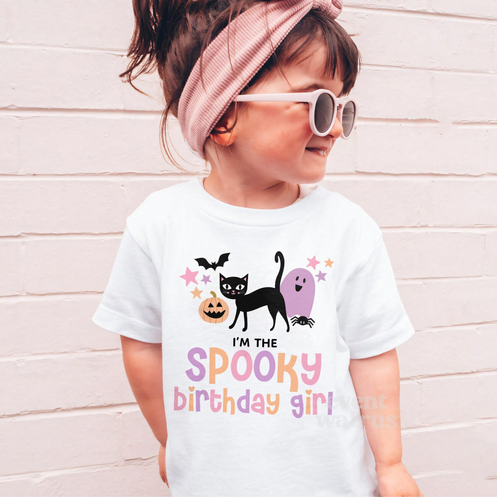 Girl in sunglasses and a pink headband wearing a white I'm the Spooky Birthday Girl shirt.