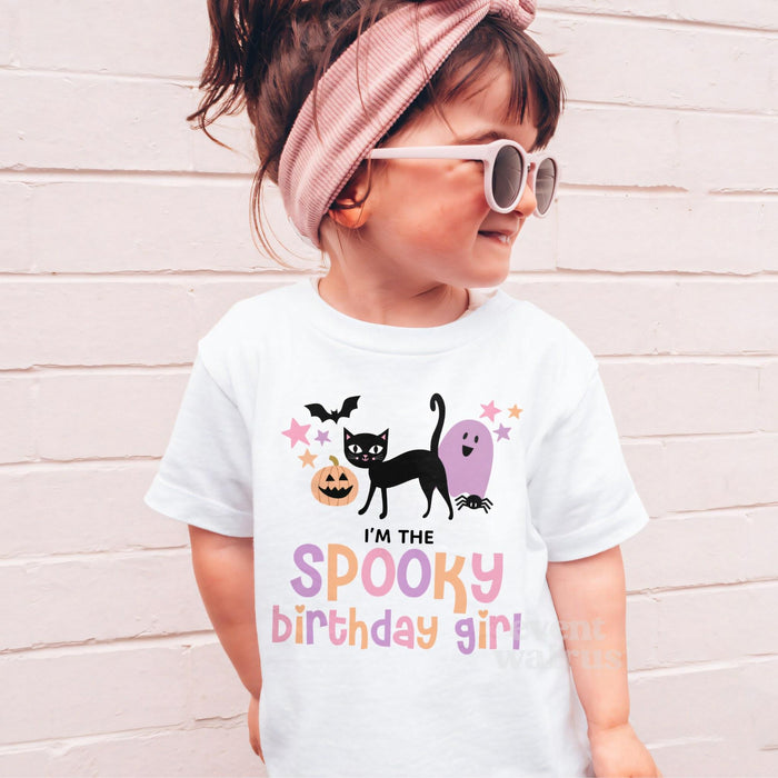 Girl in sunglasses and a pink headband wearing a white I'm the Spooky Birthday Girl shirt.