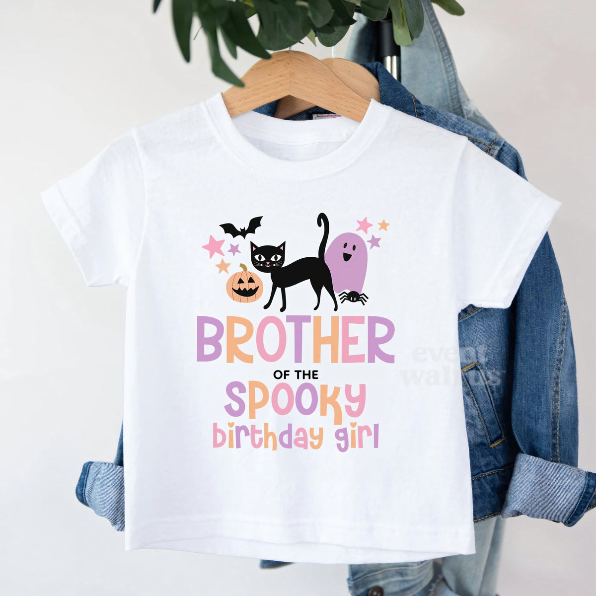 White Brother of the Spooky Birthday Girl toddler tee on a hanger over a denim jacket.