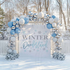 Blue glitter winter onederland backdrop in a snowy garden under a blue, white and silver balloon arch.