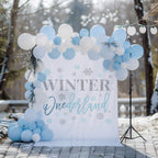 Winter onederland backdrop for a boy on a snowy patio with pale blue and white balloons.