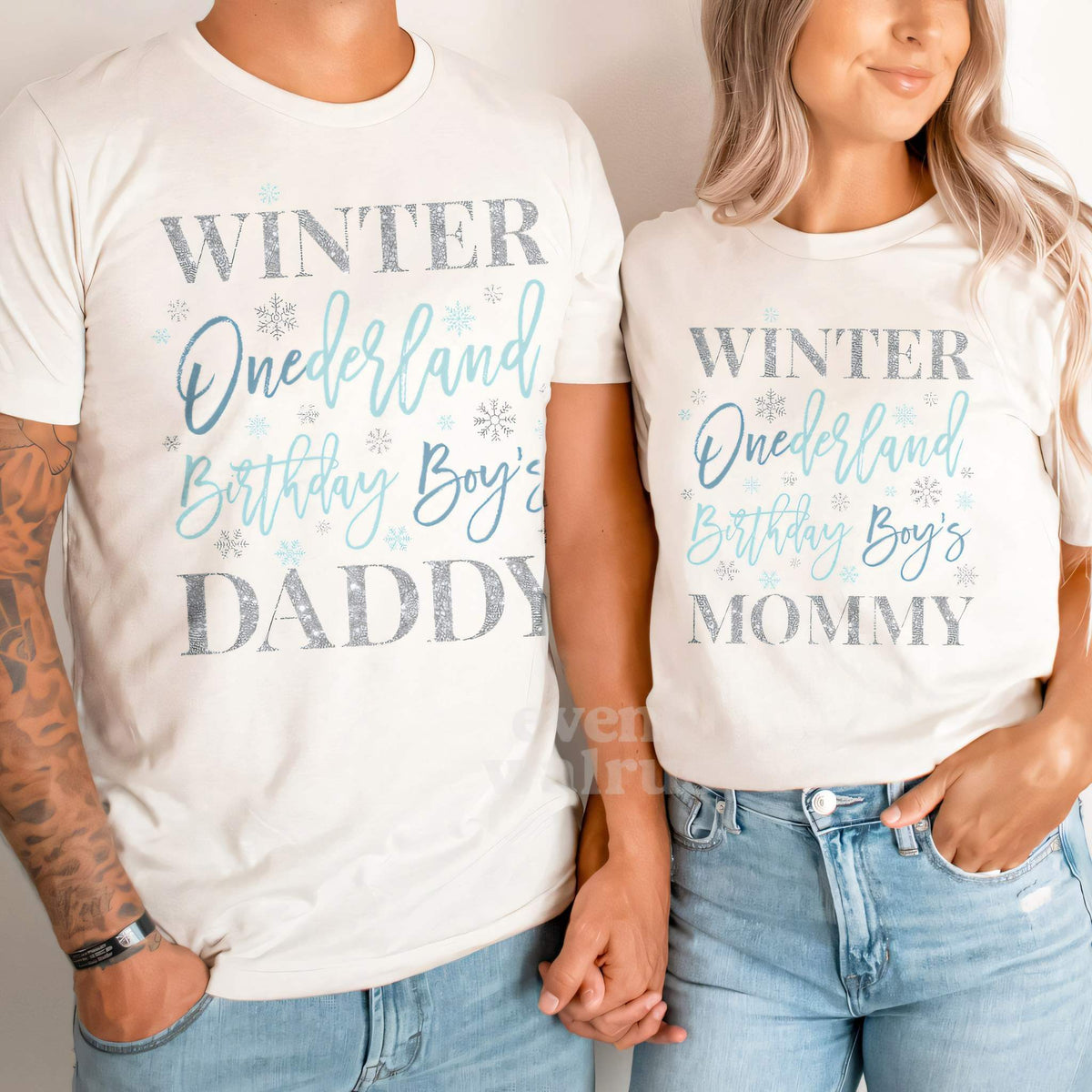 Dad and Mom holding hands in white Daddy and Mommy blue Winter Onederland shirts.