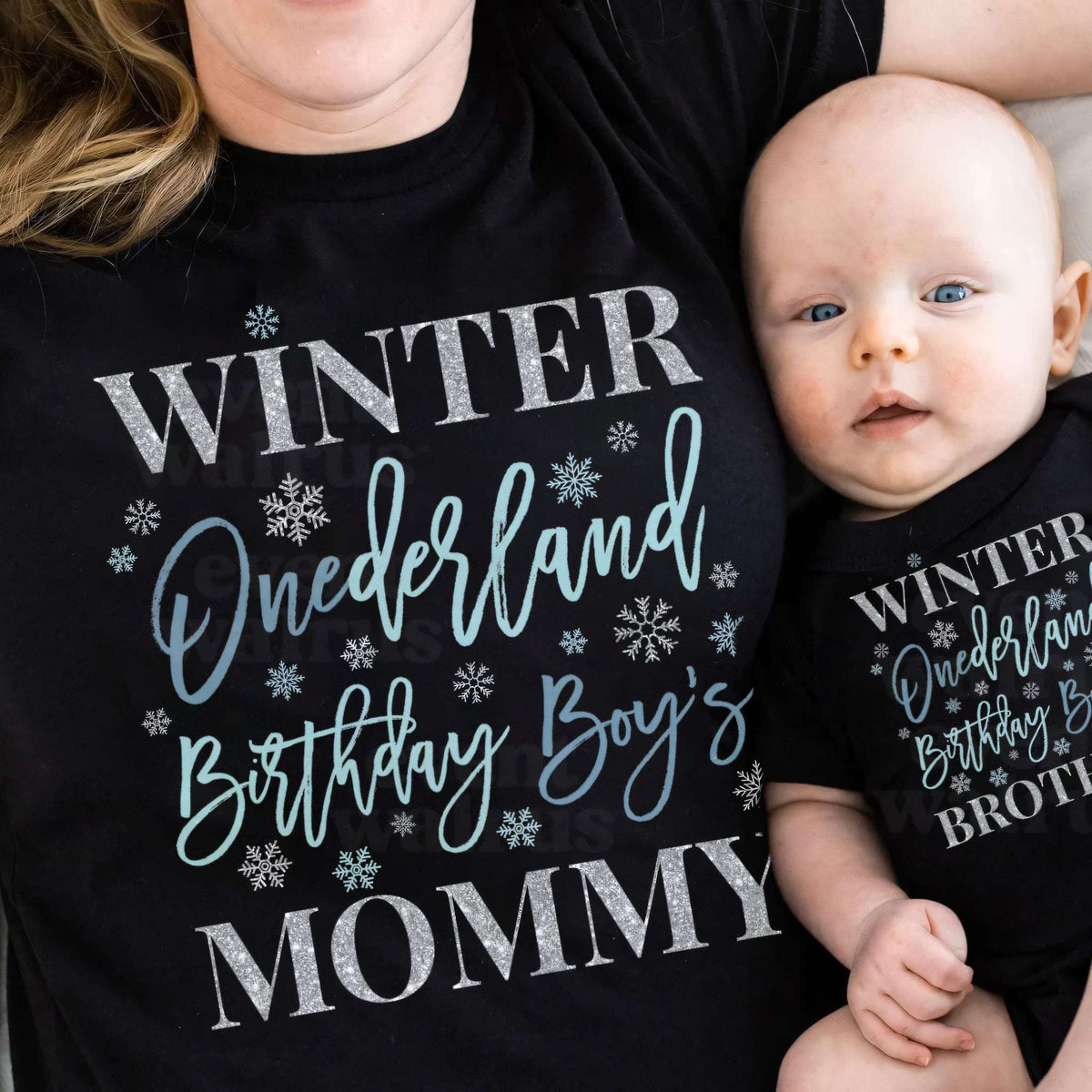 Mom and baby in black Winter Onederland Mommy and Brother shirts.