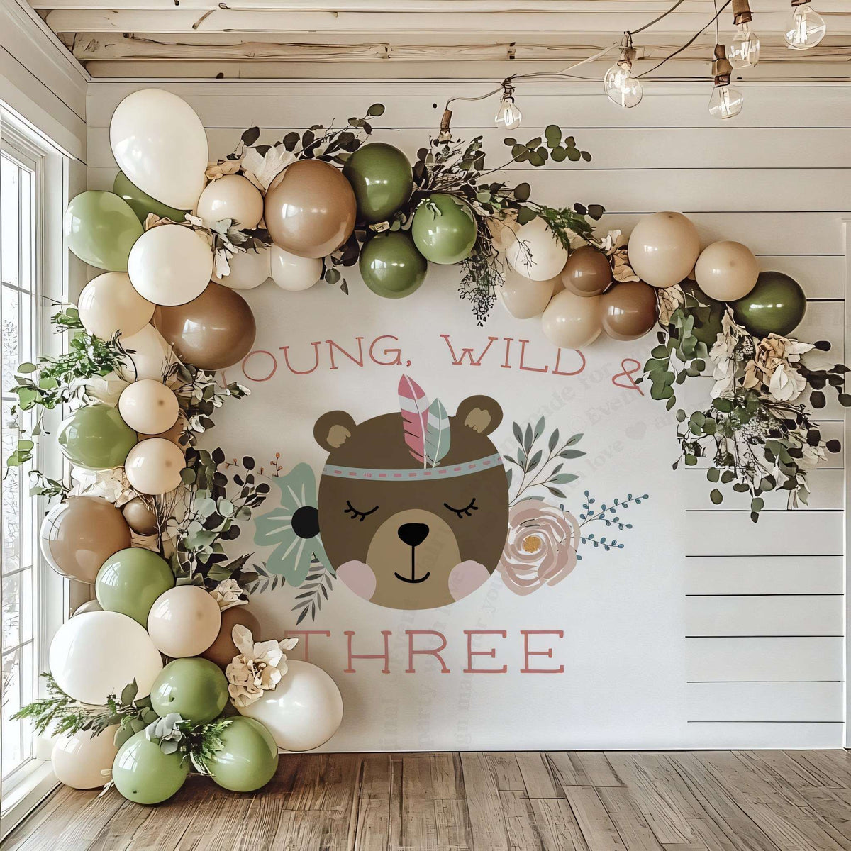 Boho bear third birthday backdrop in a white room with sage and cream balloons and greenery.