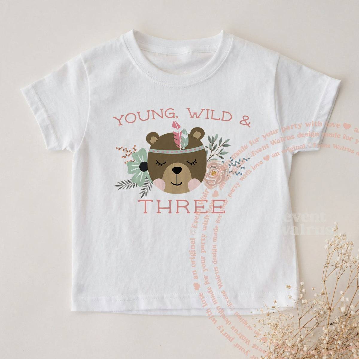 White Young, Wild and Three toddler tee laid flat with sprigs of baby's breath.