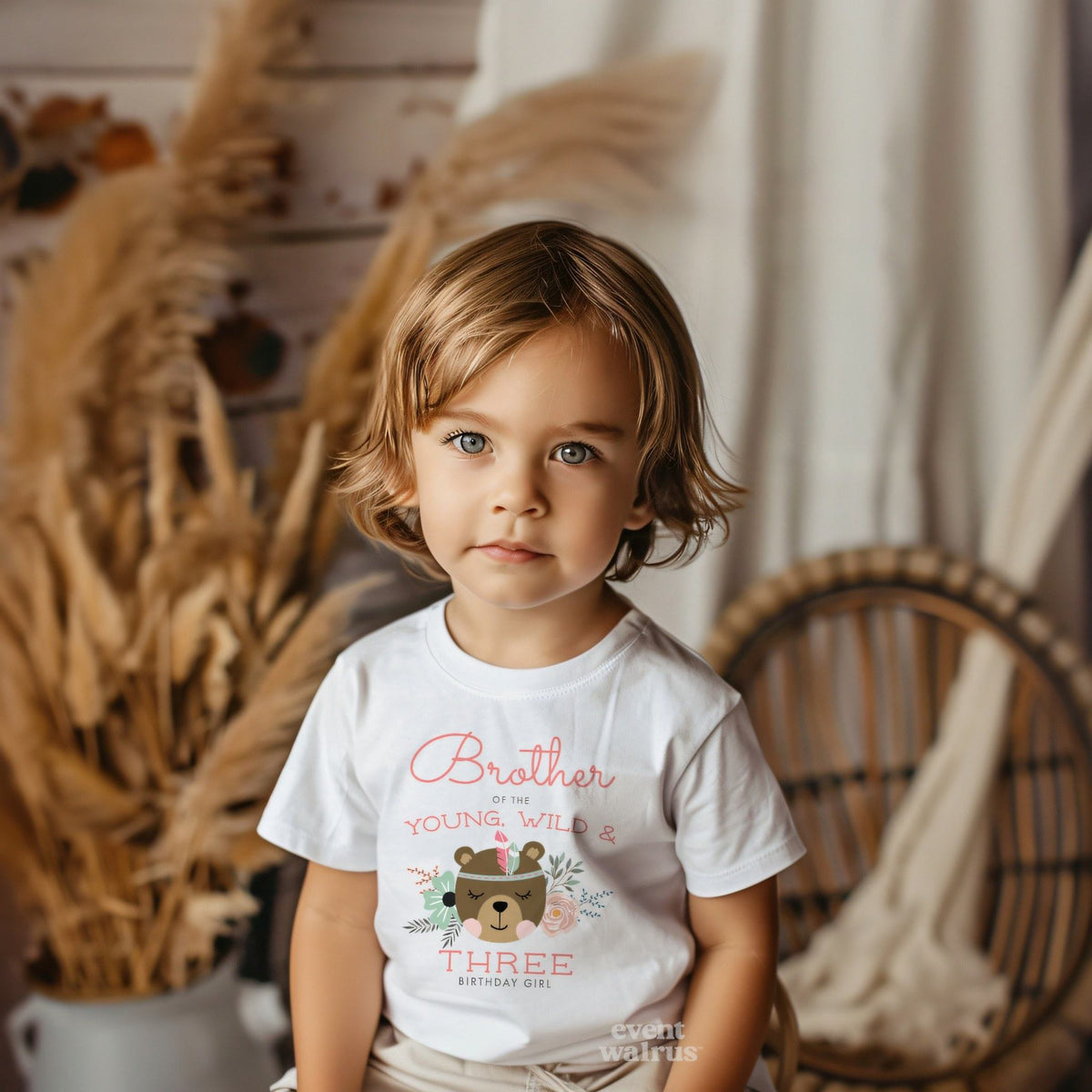Little boy in a boho room wearing a white Brother of the Young, Wild and Three tee.