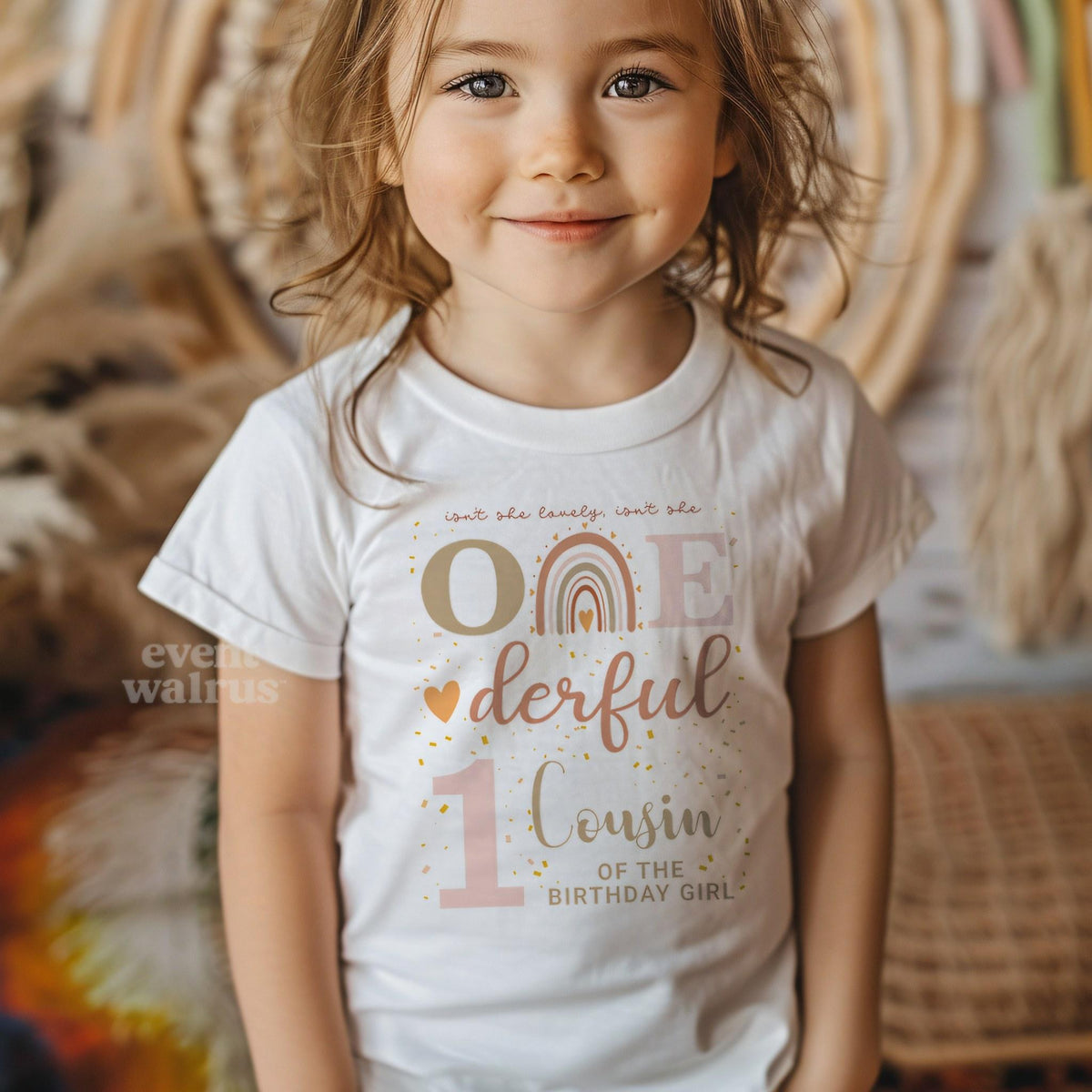 Smiling girl in a white Onederful Cousin of the Birthday Girl shirt with a boho rainbow.