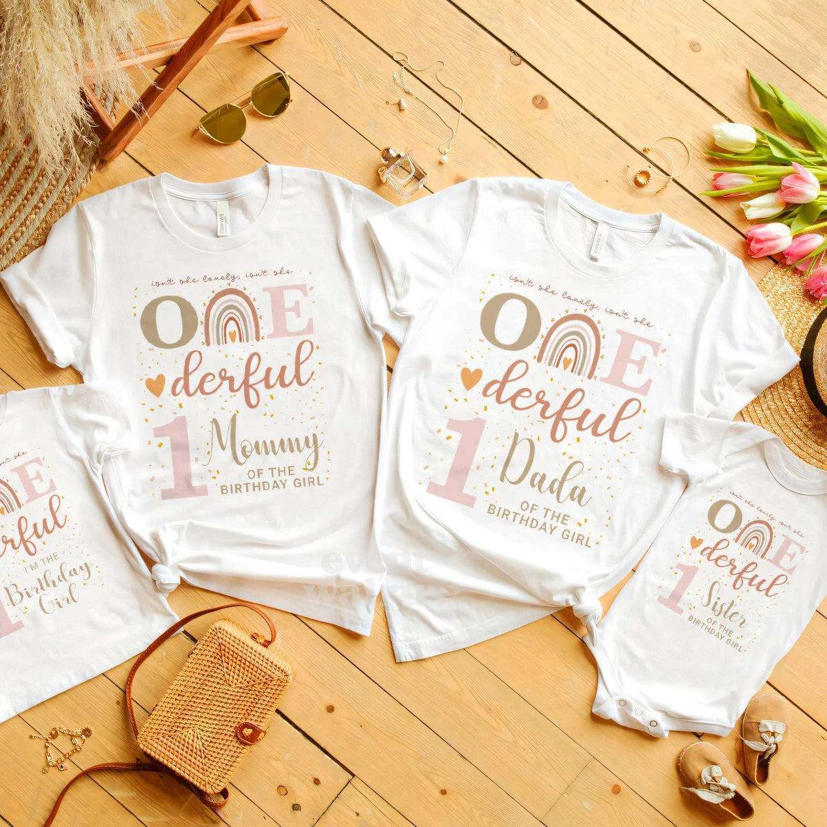 Mommy, Dada, Sister and birthday girl boho rainbow shirts laid out on a wooden floor.