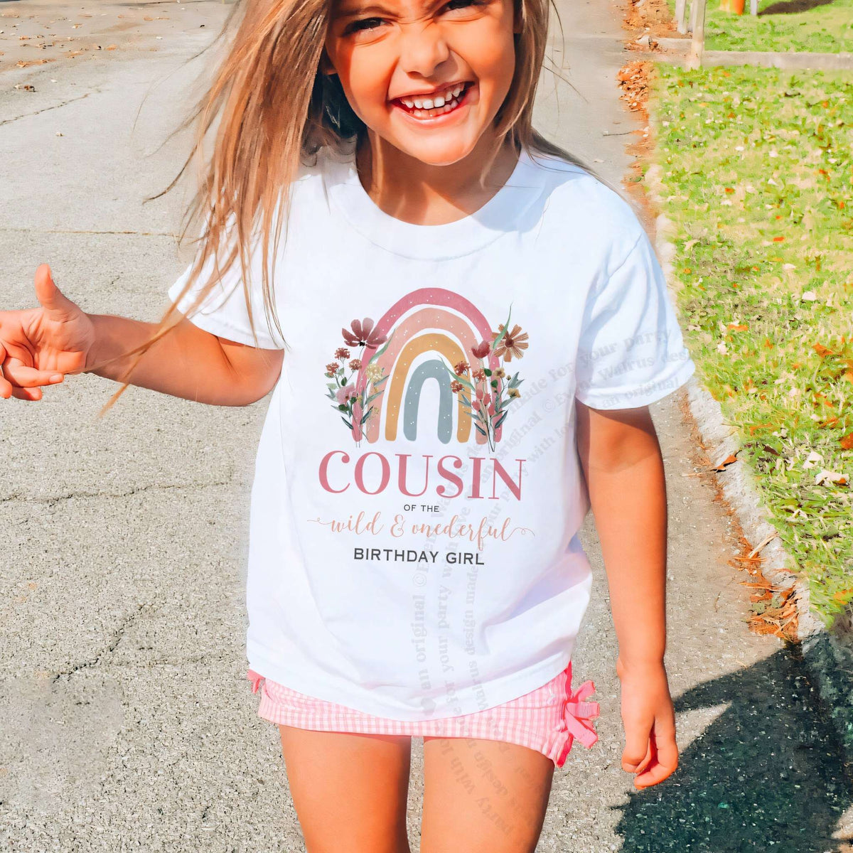 Laughing girl outdoors in a white rainbow Cousin of the Wild and Onederful kids tee.