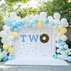 Chocolate donut two sweet backdrop in a garden with blue balloons and hydrangeas.