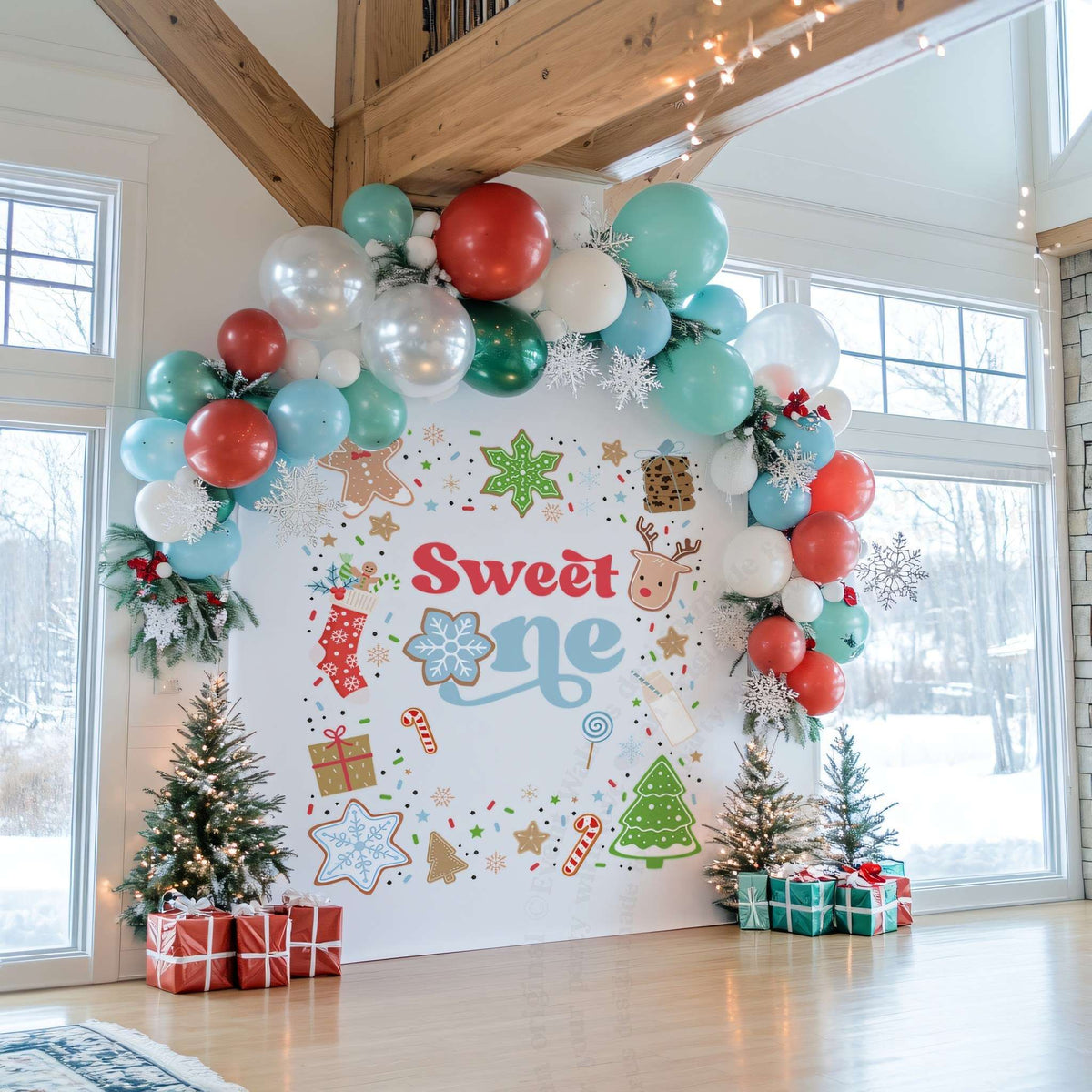 Sweet one backdrop between two small Christmas trees with red and teal wrapped gifts.