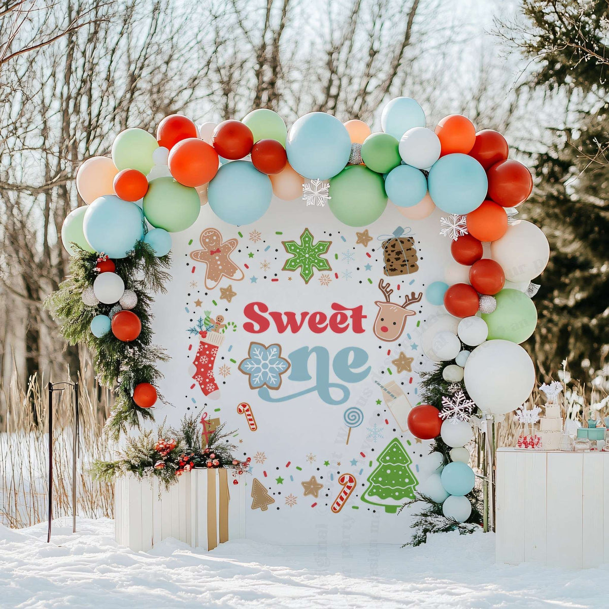 Sweet One cookie backdrop in a snowy yard with red, green and white balloons.