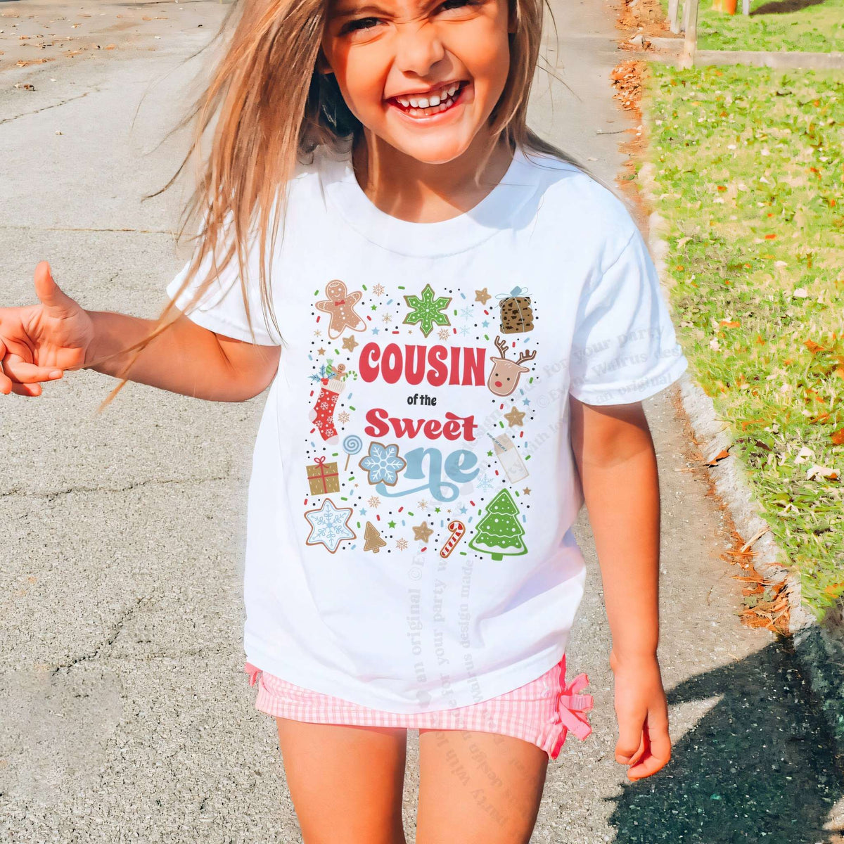 Laughing girl outdoors in a white Cousin of the Sweet One kids tee.
