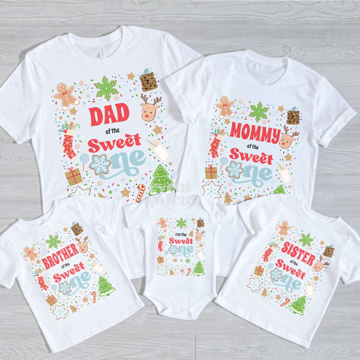 Dad, Mommy, Brother, Sister and baby Sweet One shirts laid out on gray wood.