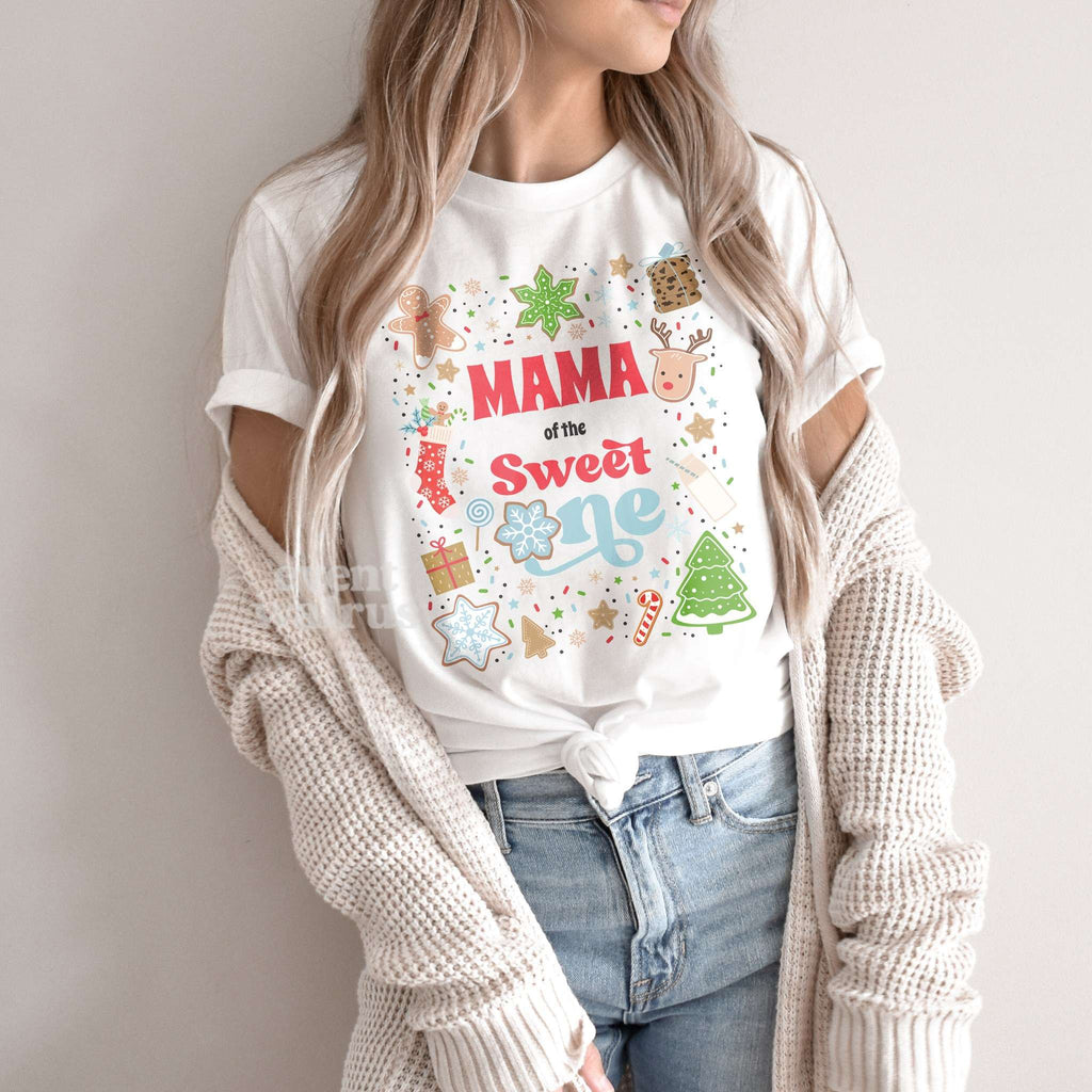 Woman in a knit cardigan wearing a white Mama of the Sweet One shirt.