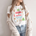Woman in a knit cardigan wearing a white Mama of the Sweet One shirt.