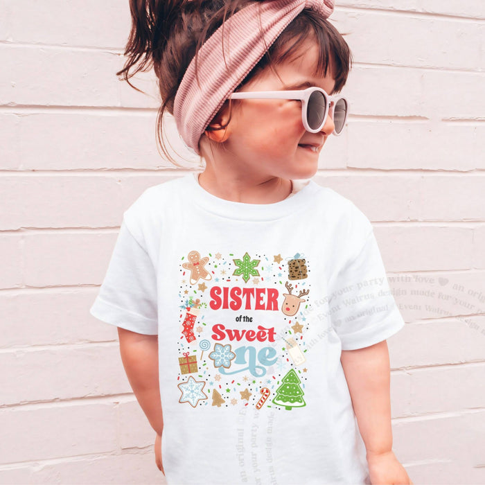 Girl in sunglasses and a pink headband wearing a white Sister of the Sweet One shirt.