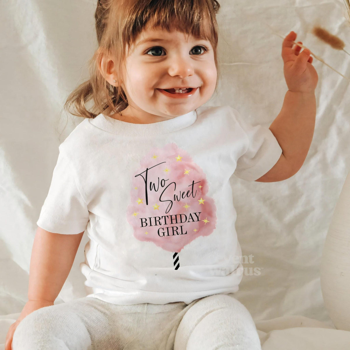 Laughing little girl in a white Two Sweet Birthday Girl tee.