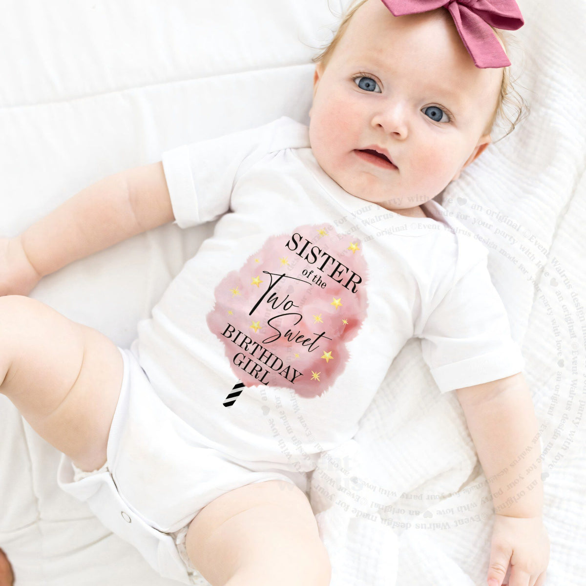 Baby girl with a pink bow lying in a white Sister of the Two Sweet bodysuit.