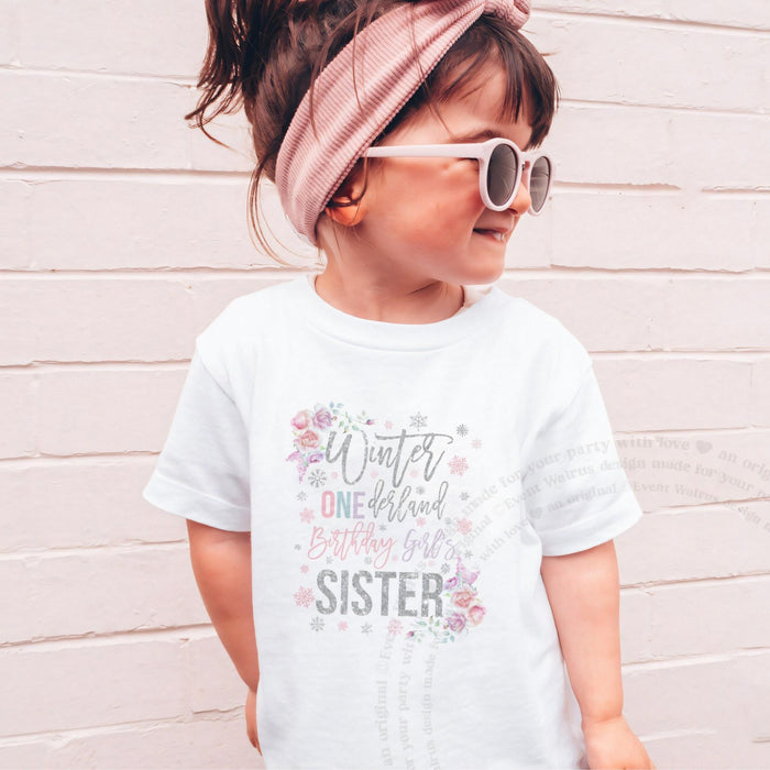 Girl in sunglasses and a pink headband wearing a white floral Winter ONEderland Sister shirt.