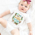 Baby girl with a pink bow in a white Four Ever Wild Sister bodysuit.