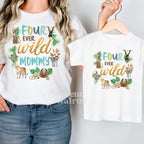 Woman in a white Four Ever Wild Mommy tee holding a matching kids shirt on a hanger.