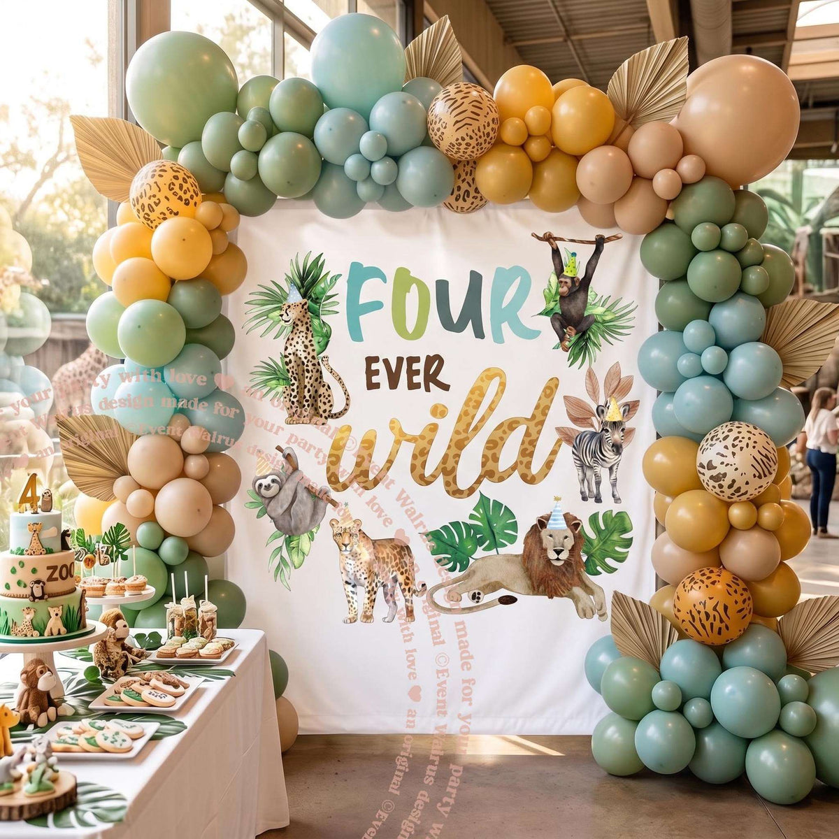 Four ever wild backdrop under a sage, gold and teal balloon arch at a zoo-themed party.