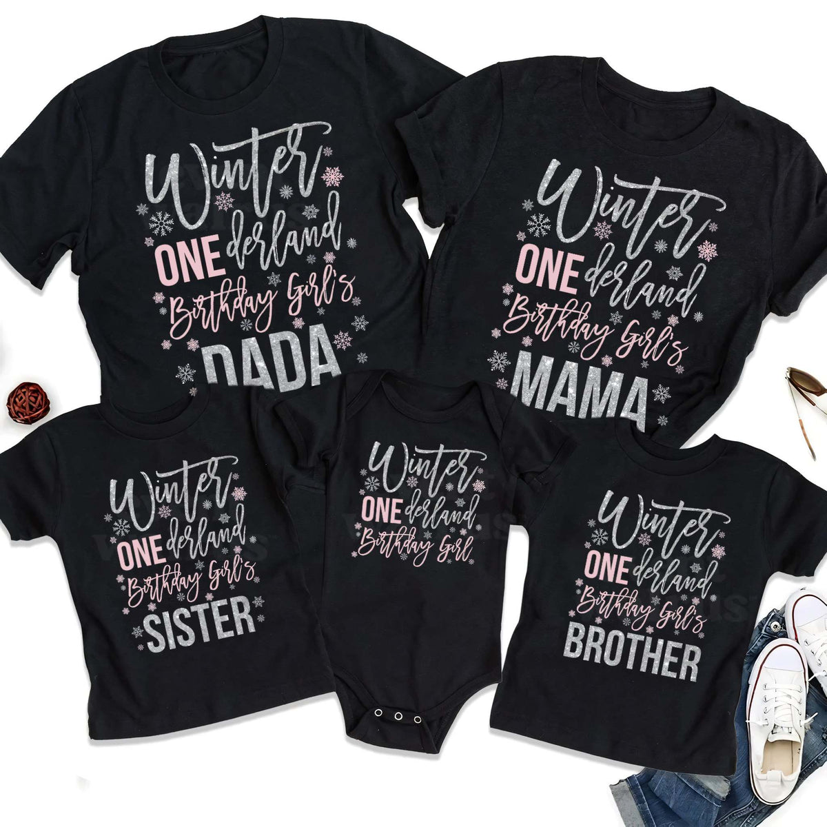 Black Dada, Mama, Sister, Brother and baby Winter ONEderland shirts laid out together.