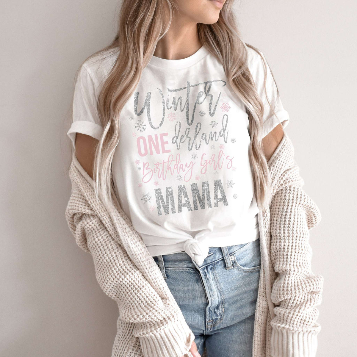 Woman in a knit cardigan wearing a white Winter ONEderland Birthday Girl's Mama shirt.