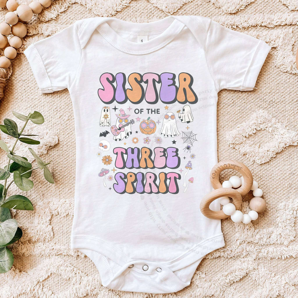 White Sister of the Three Spirit bodysuit on a beige blanket with a wooden teether.