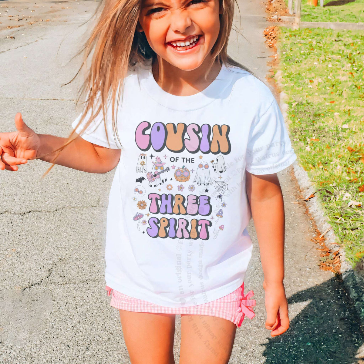 Laughing girl outdoors in a white Cousin of the Three Spirit kids tee.