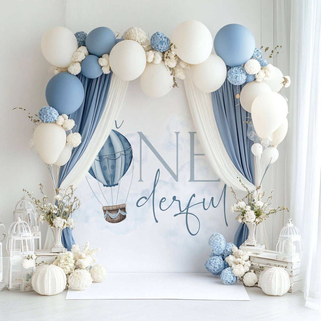 Mr Onederful backdrop under a draped arch of blue and cream fabric and balloons.